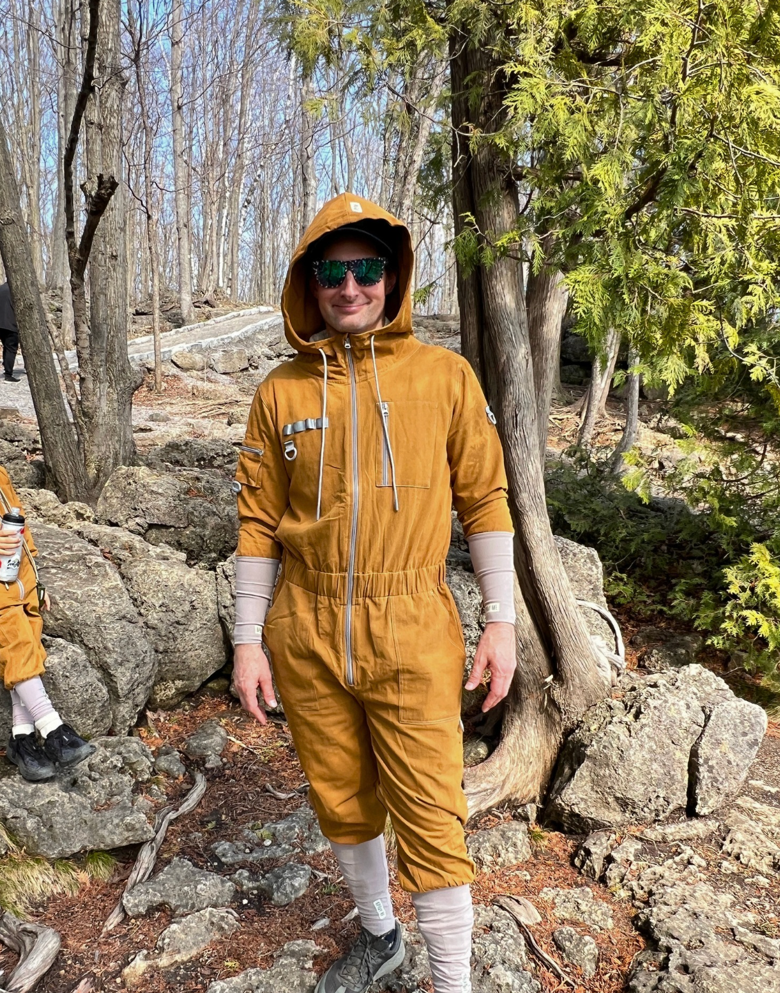 Adult wearing a TickOffTick Tick protection suit while hiking on a forest trail